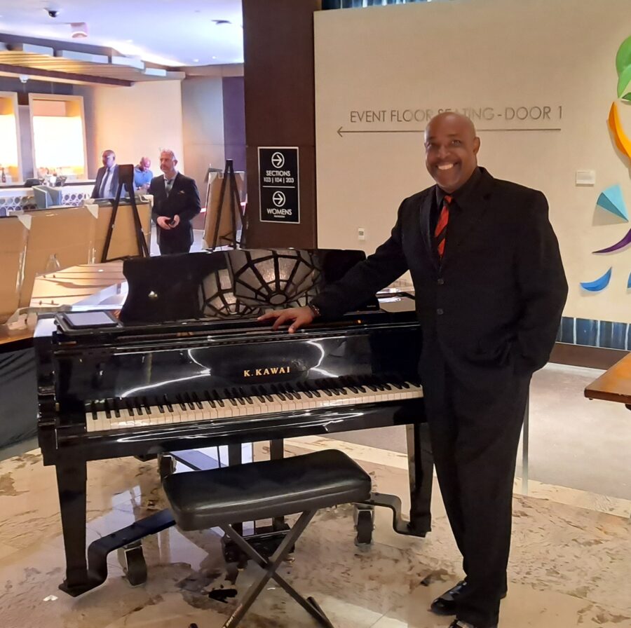 Kevin Howard standing near his Piano.